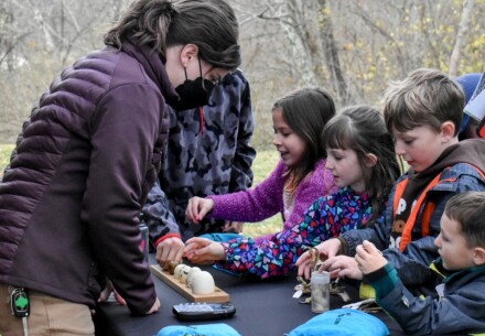 kids with woman looking at bird items